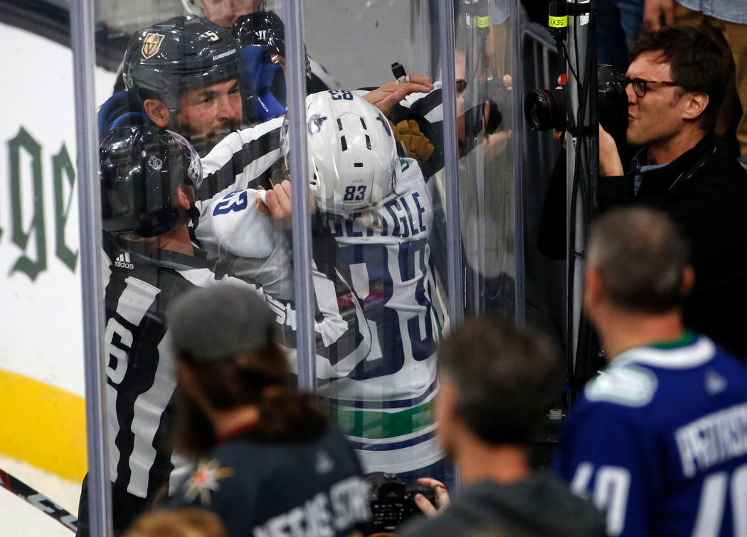 Vegas Golden Knights defenseman Deryk Engelland (5) fights with Vancouver Canucks center Jay Be ...