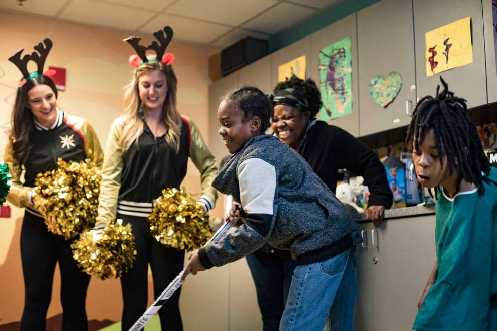 Rochelle J., from left, Paige N., both members of the Knights Guard, cheer on Titan Bickhem, 7, ...