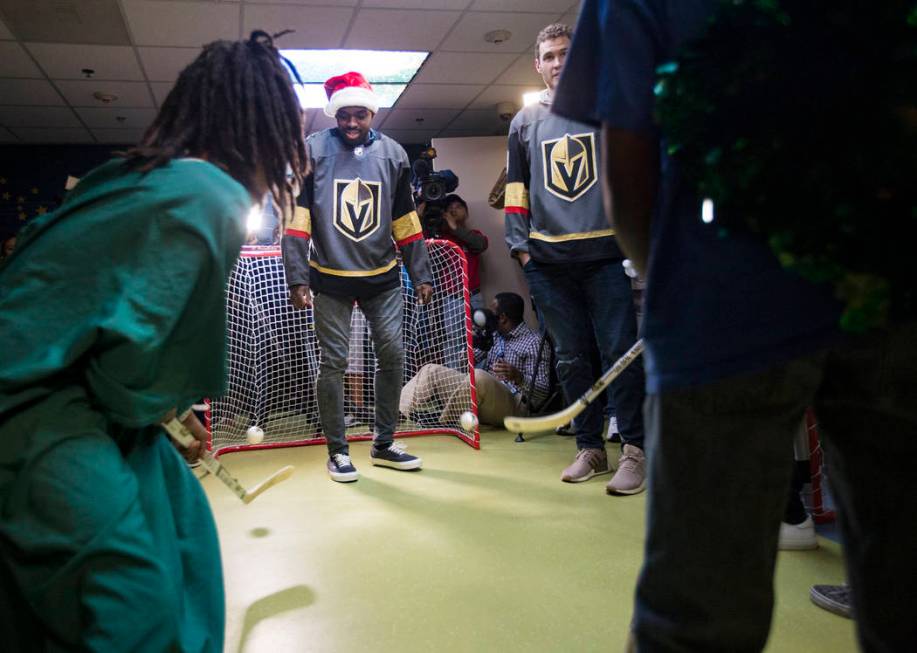 Golden Knights player Malcolm Subban guards the goal against Titan Bickhem, 7, and his brother ...