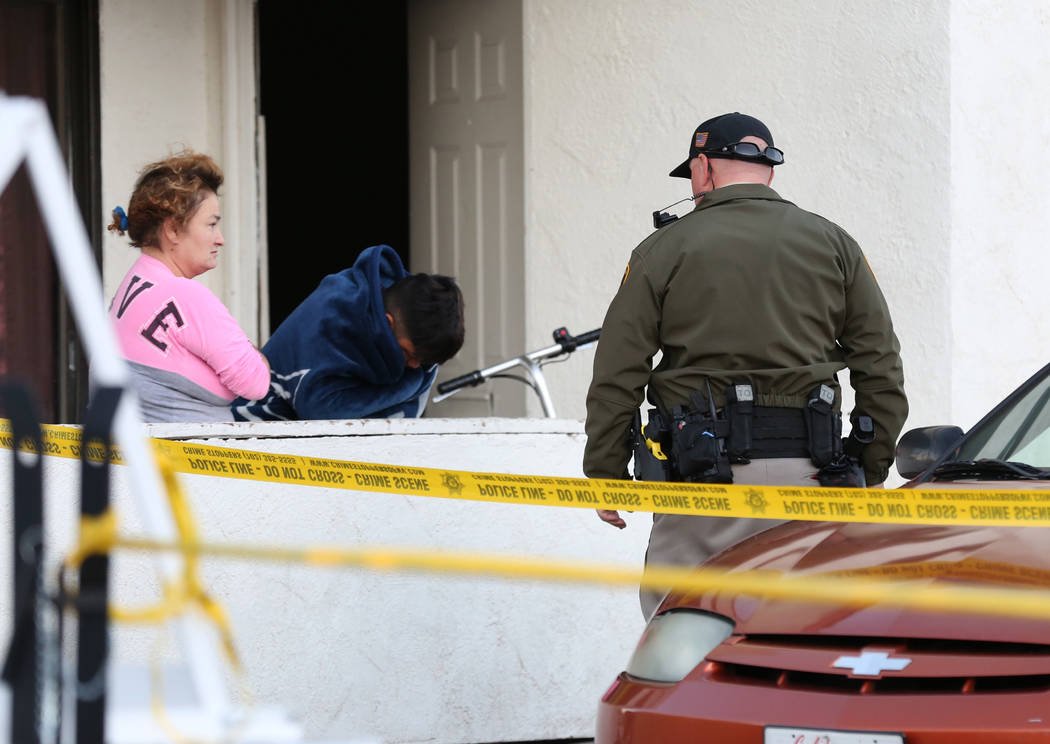 A Metropolitan Police Department officer talks to residents at the 2300 block of Exeter Drive, ...