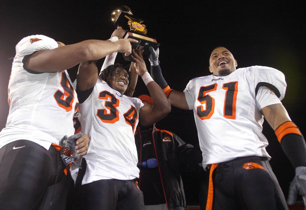 Oregon State players, from left, Dwan Edwards, Steven Jackson and Richard Seigler hoist the Las ...