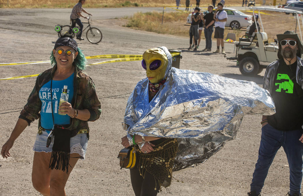 Festivalgoers wander on past the Little A'Le'Inn during the Alienstock festival on Friday, Sept ...