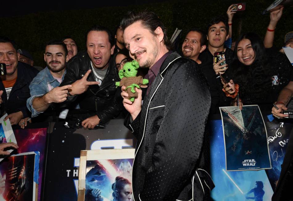 Pedro Pascal holds a baby Yoda doll as poses with fans at the world premiere of "Star Wars ...