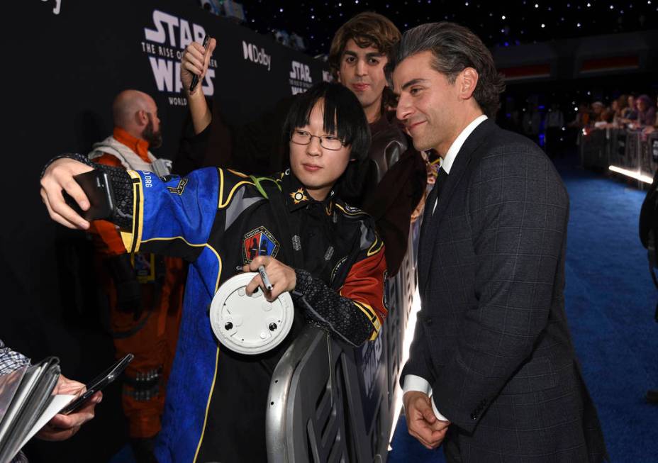 Oscar Isacc, right, takes a selfie with a fan as he arrives at the world premiere of "Star ...