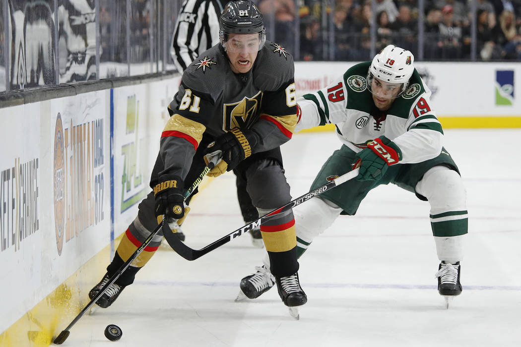 Vegas Golden Knights right wing Mark Stone (61) skates around Minnesota Wild center Luke Kunin ...