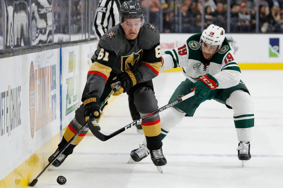 Vegas Golden Knights right wing Mark Stone (61) skates around Minnesota Wild center Luke Kunin ...