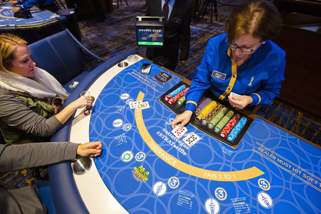 Blackjack dealer Amal Almisber, right, works the table as John and Shannon Welt, of Grants Pass ...