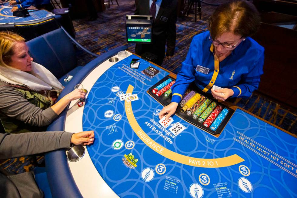 Blackjack dealer Amal Almisber, right, works the table as John and Shannon Welt, of Grants Pass ...