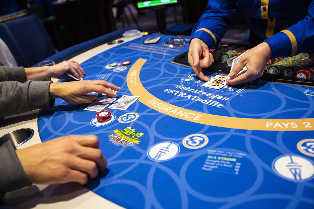 Blackjack dealer Amal Almisber, right, works the table as John and Shannon Welt, of Grants Pass ...