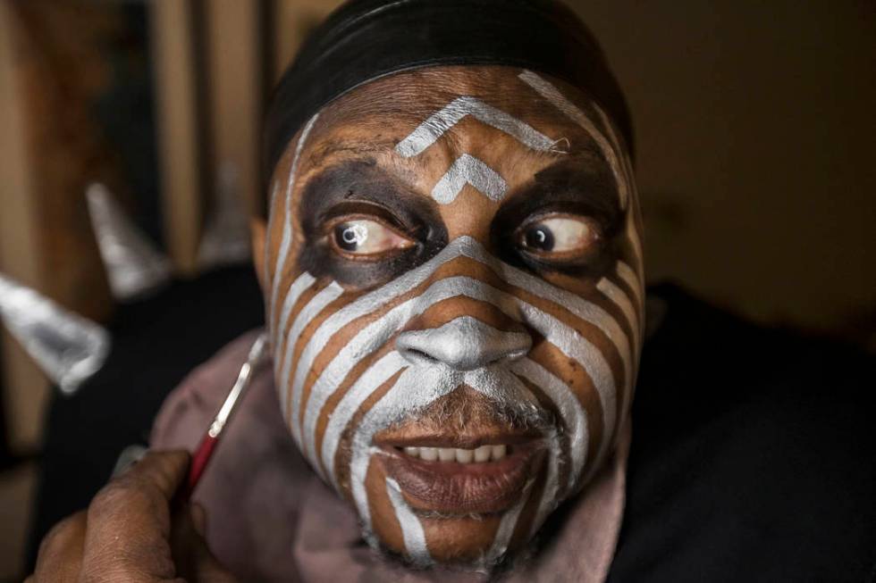 Raiders super fan Wayne Mabry, known as "Violator," applies makeup in his hotel room ...