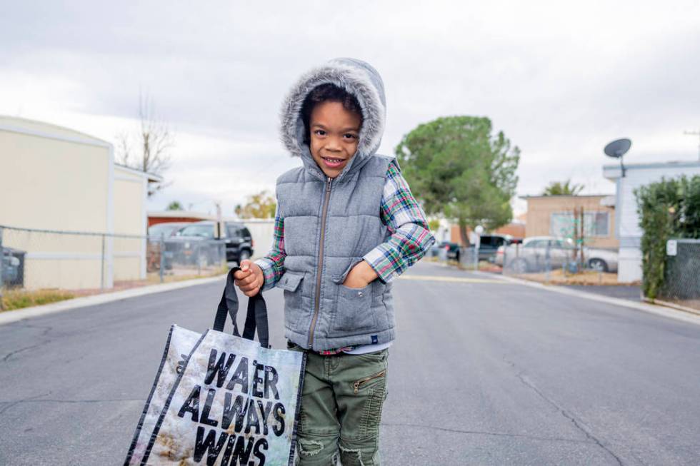 Olamide Ajayi, 6, holds a surprise gift of $1,000 raised for his mentor Lisa Bernauer, for her ...