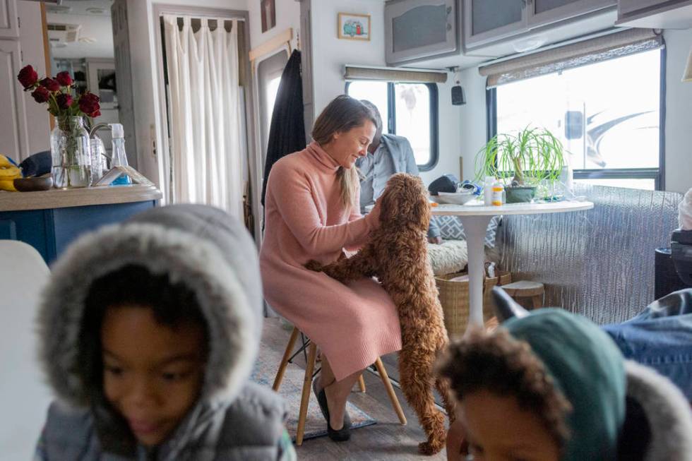 Jill Ajayi, center, pets Nalulani, Lisa Bernauer's therapy dog, at Bernauer's home in Las Vegas ...