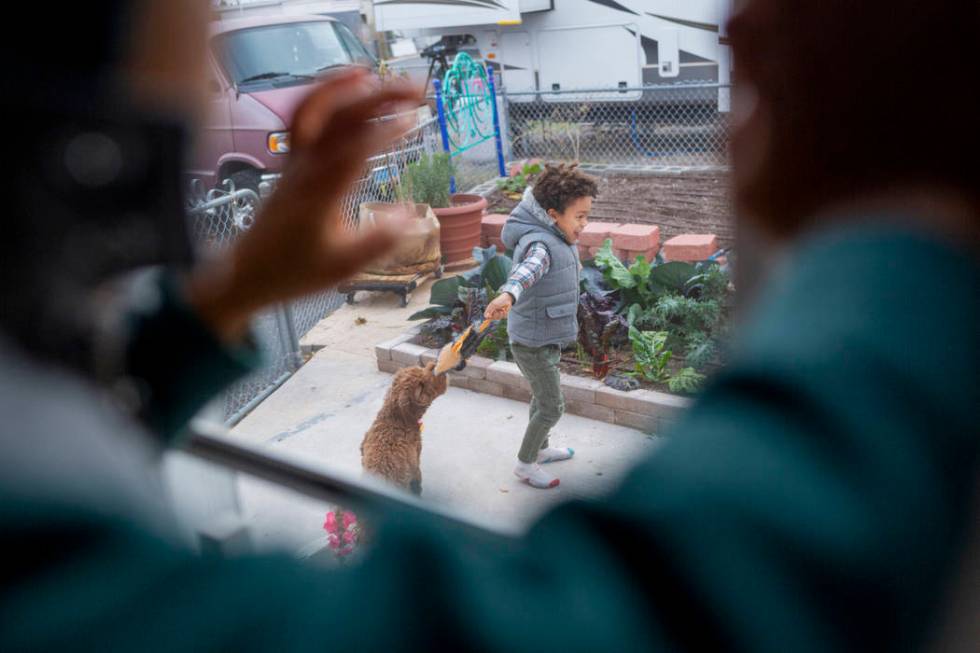 Ayotunde Ajayi, 4, left, watches his brother Olamide Ajayi, 6, play with Nalulani, their mentor ...