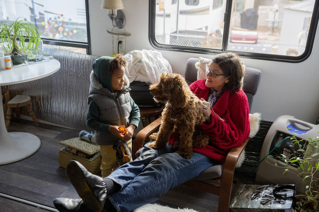 Ayotunde Ajayi, 4, listens as his education mentor Lisa Bernauer discuss her journey with her c ...