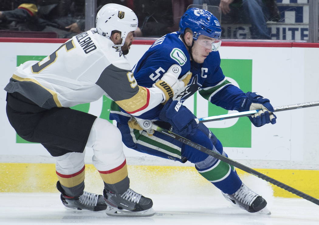 Vegas Golden Knights defenseman Deryk Engelland (5) vies for control of the puck with Vancouver ...