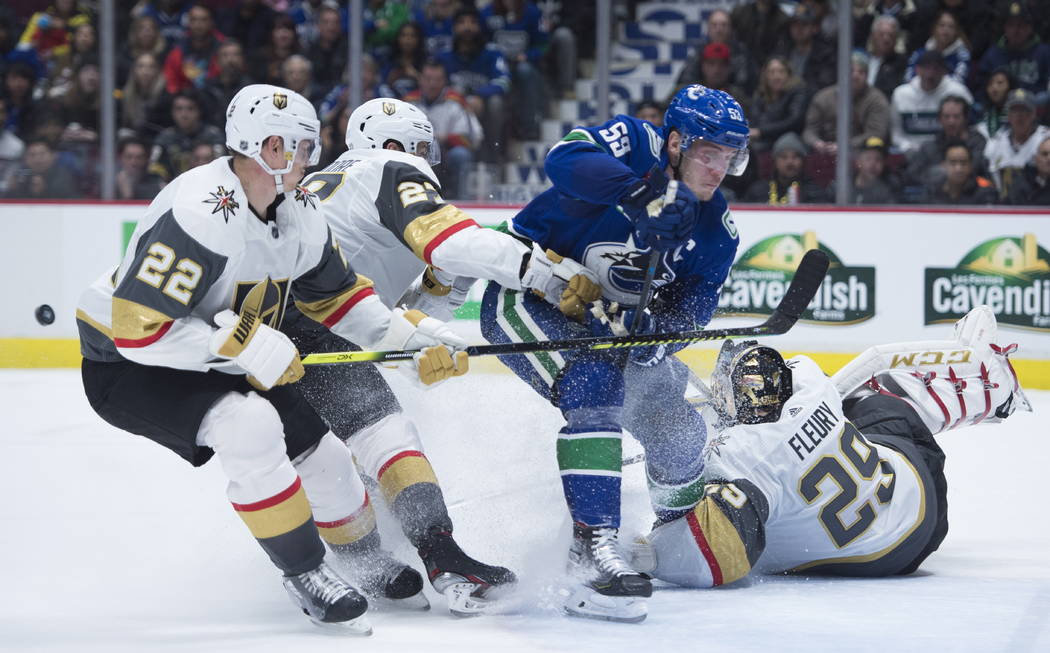 Vegas Golden Knights defenseman Nick Holden (22) and Shea Theodore (27) stop Vancouver Canucks ...