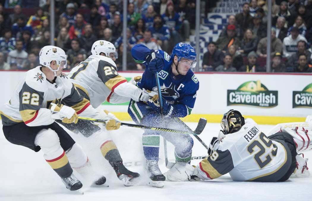 Vegas Golden Knights' Nick Holden (22) and Shea Theodore (27) stop Vancouver Canucks' Bo Horvat ...