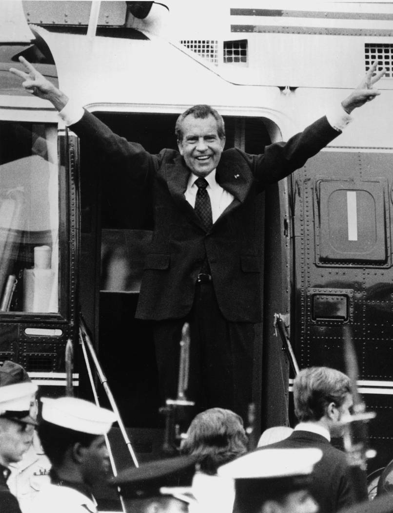 Richard Nixon says goodbye with a victorious salute to his staff members outside the White Hous ...