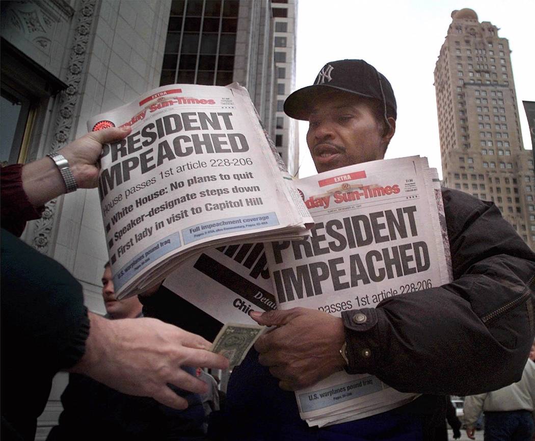 R.C. Stewart sells a newspaper with the banner headline "Clinton Impeached" on Michigan Avenue ...