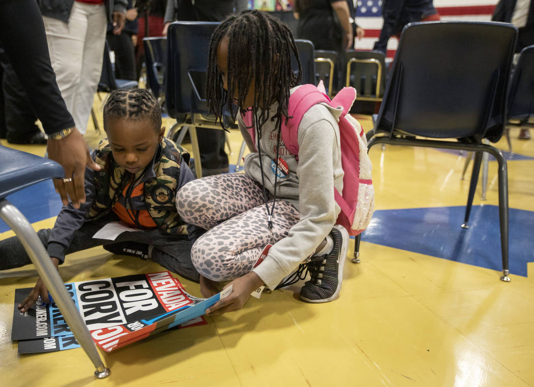 Jojo Faye, 5, left, and his sister Lillian Faye, 9, right, pick up signs as they're about to le ...