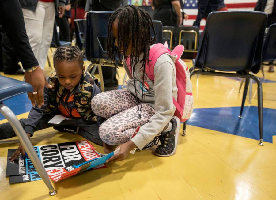 Jojo Faye, 5, left, and his sister Lillian Faye, 9, right, pick up signs as they're about to le ...