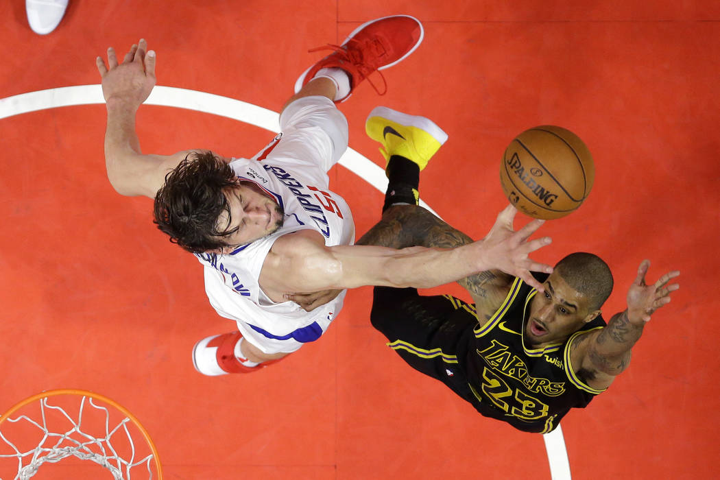 Los Angeles Lakers guard Gary Payton II, right, shoots as Los Angeles Clippers center Boban Mar ...