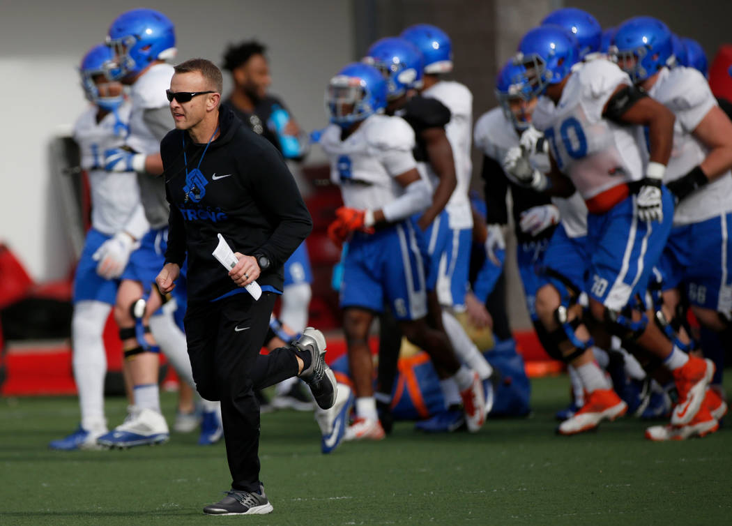 Boise State head coach Bryan Harsin, left, runs with his players during football practice in La ...