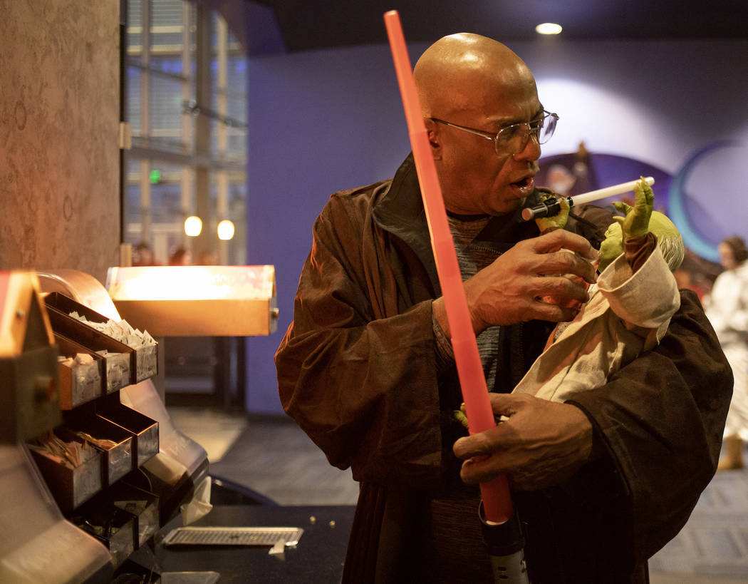 George R. Addison III pretends to feed his Yoda doll at the Star Wars: The Rise of Skywalker pr ...