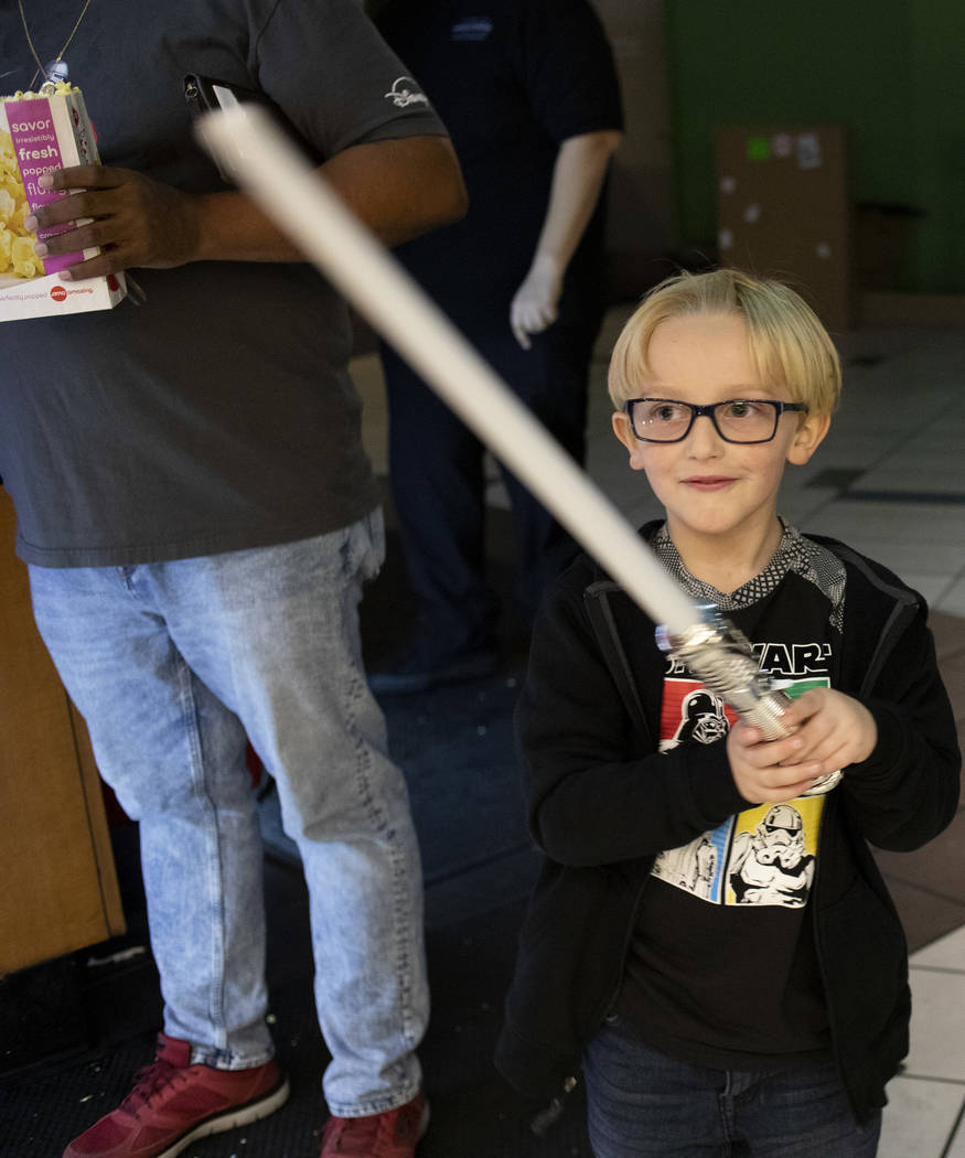 John Athan, 6, waves his light saber at the Star Wars: The Rise of Skywalker premiere at AMC To ...