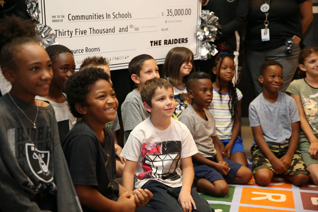 Students smile for a photo after the Raiders presented a $35,000 donation to Communities In Sch ...