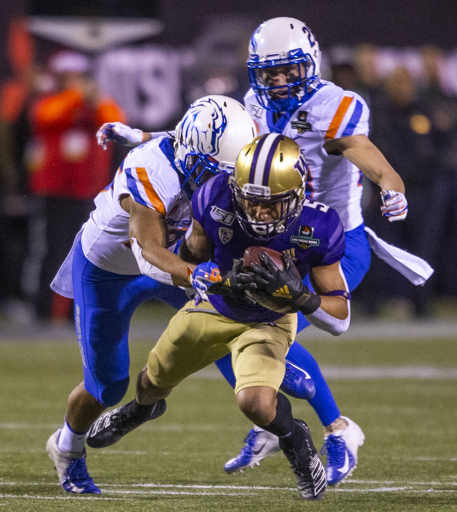 Washington Huskies wide receiver Andre Baccellia (5, front) is finally taken down by Boise Stat ...