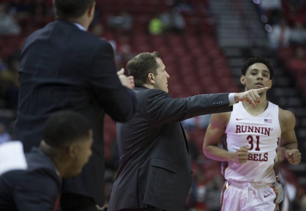 UNLV Rebels head coach T.J. Otzelberger, middle, gives direction to UNLV Rebels guard Marvin Co ...