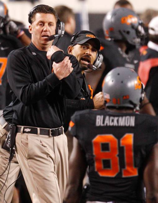 Oklahoma State head coach Mike Gundy, left, and wide receiver coach Kasey Dunn, center, shout t ...