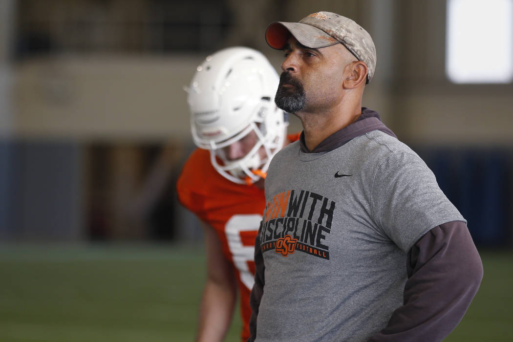 Oklahoma State's Kasey Dunn, associate head coach/receivers coach, watches during an NCAA colle ...