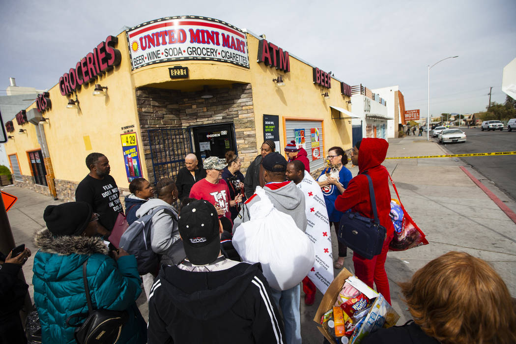 Displaced residents gather outside of the Alpine Apartment Motel, where an early morning fire l ...