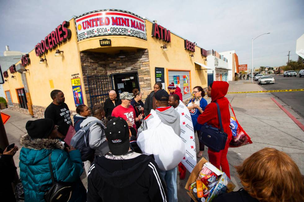 Displaced residents gather outside of the Alpine Apartment Motel, where an early morning fire l ...