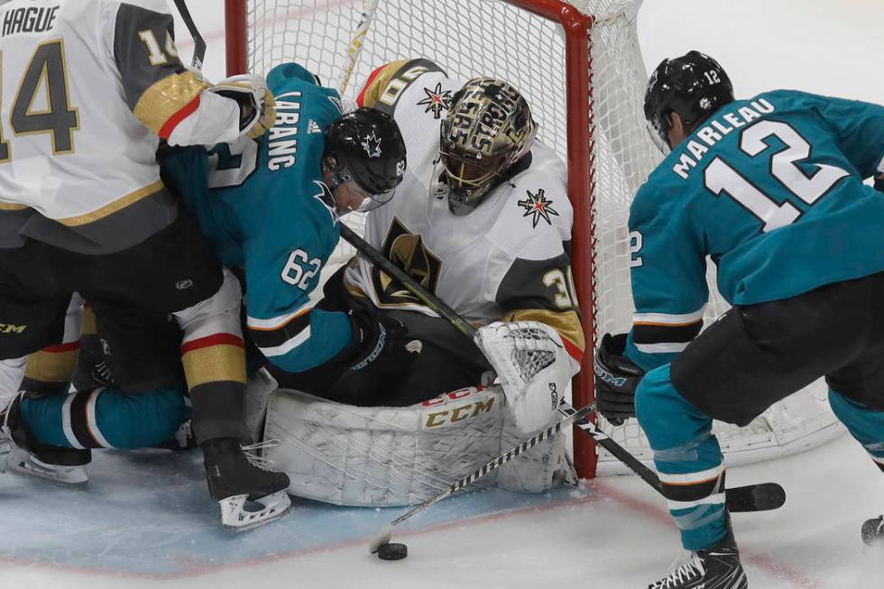 Vegas Golden Knights goaltender Malcolm Subban, center, defends the net as San Jose Sharks righ ...