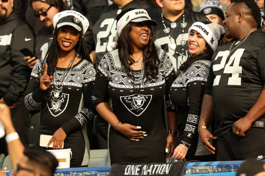 Oakland Raiders fans don matching holiday outfits during the first half of an NFL game against ...