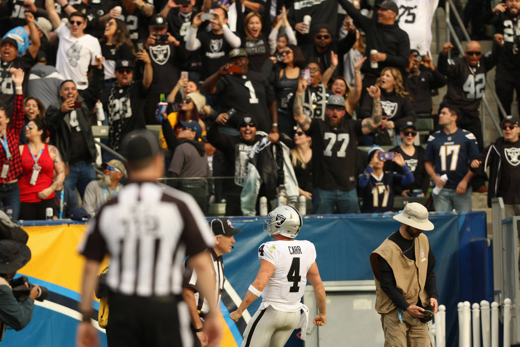 Oakland Raiders quarterback Derek Carr (4) celebrates his touchdown as the crowd cheers during ...
