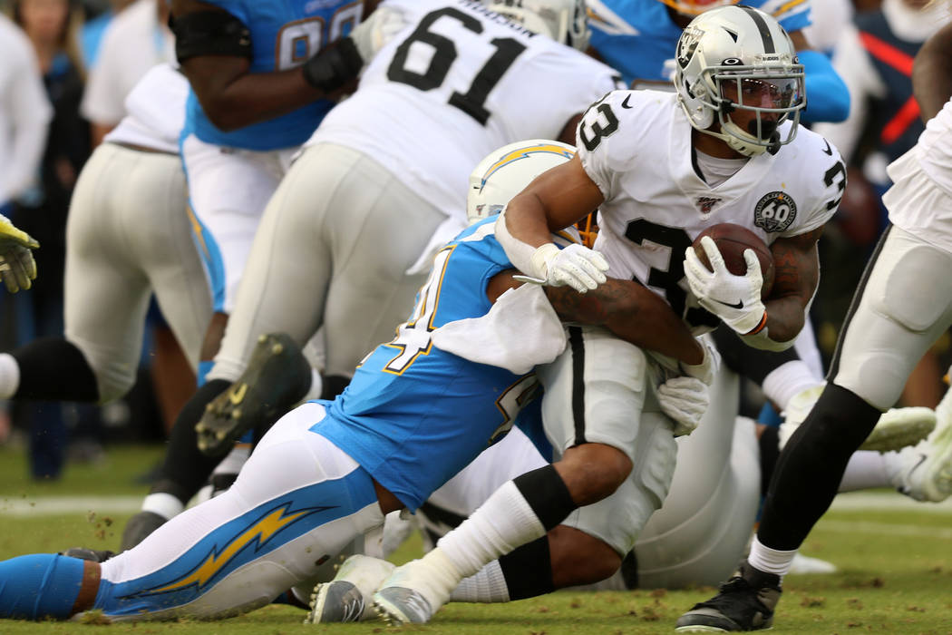 Oakland Raiders running back DeAndre Washington (33) is tackled by Los Angeles Chargers outside ...