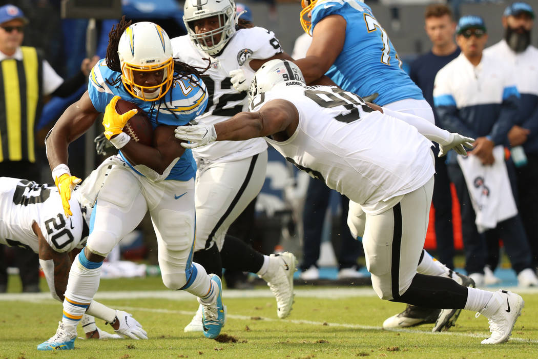 Los Angeles Chargers running back Melvin Gordon (25) tries to break a tackle from Oakland Raide ...