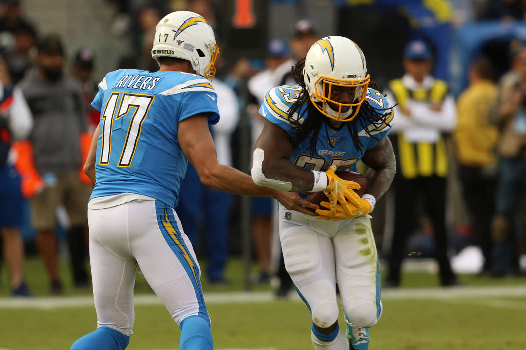 Los Angeles Chargers quarterback Philip Rivers (17) hands off the football to running back Melv ...