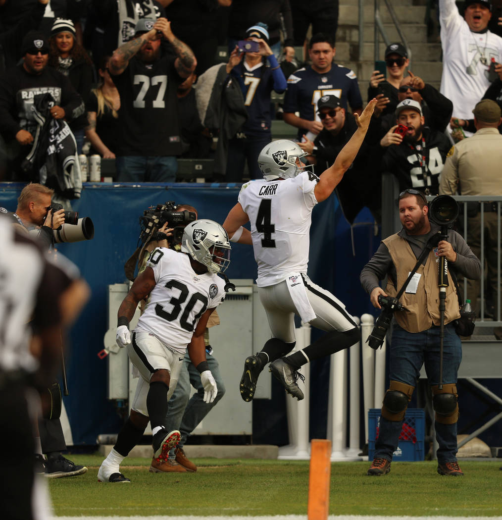 Oakland Raiders quarterback Derek Carr (4) celebrates his touchdown with running back Jalen Ric ...
