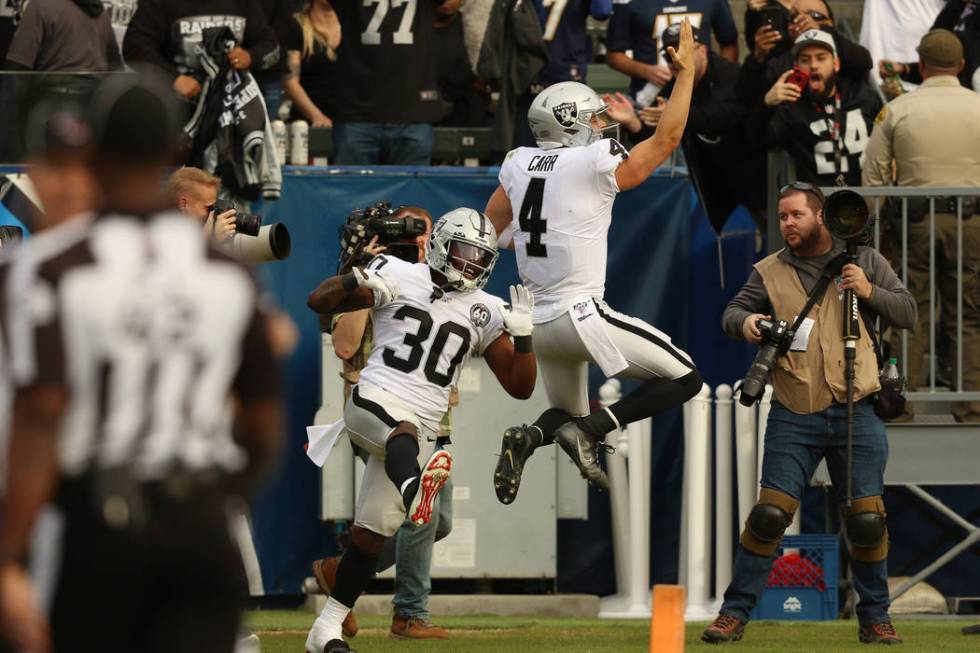 Oakland Raiders quarterback Derek Carr (4) celebrates his touchdown with running back Jalen Ric ...