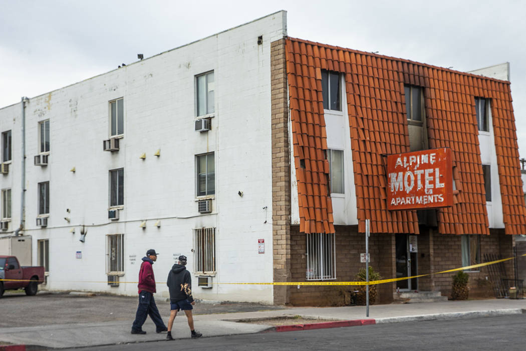 Pedestrians walk past the Alpine Motel Apartments with crime tape still in place on Sunday, Dec ...