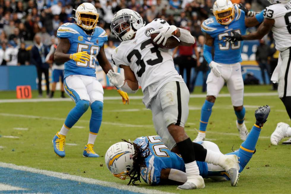 Oakland Raiders running back DeAndre Washington, right, scores past Los Angeles Chargers strong ...