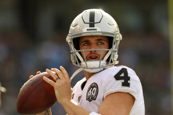 Oakland Raiders quarterback Derek Carr (4) warms up on the sideline during the first half of an ...