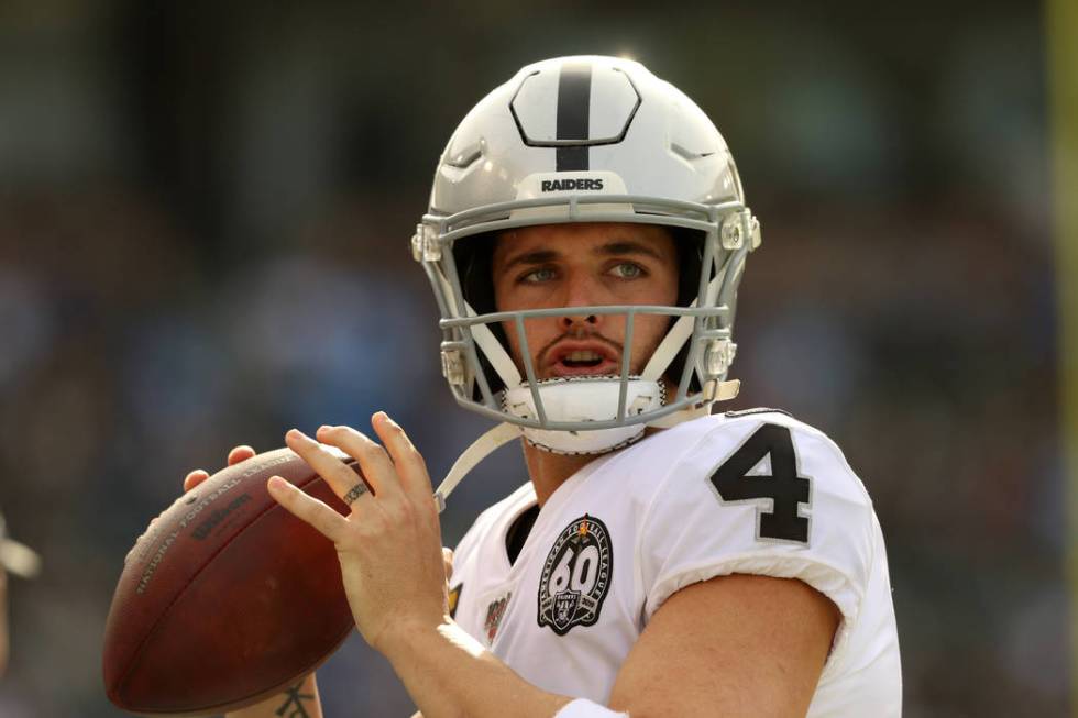 Oakland Raiders quarterback Derek Carr (4) warms up on the sideline during the first half of an ...