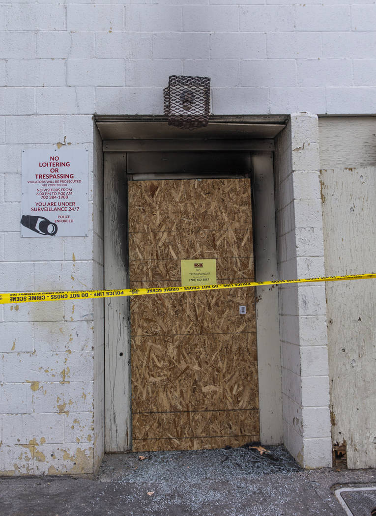 The broken rear glass door of the Alpine Apartment Motel is now boarded up and lines with crime ...