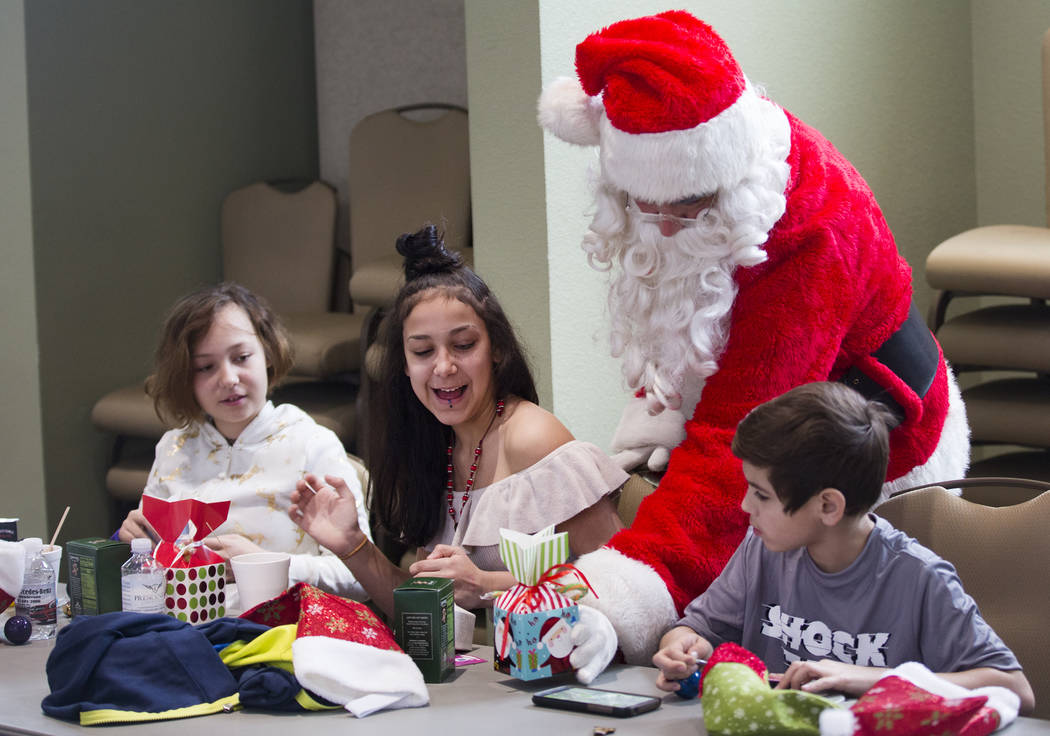 Santa Claus passes out gifts to survivors of the Alpine motel fire from left Brianna Aikens, 11 ...